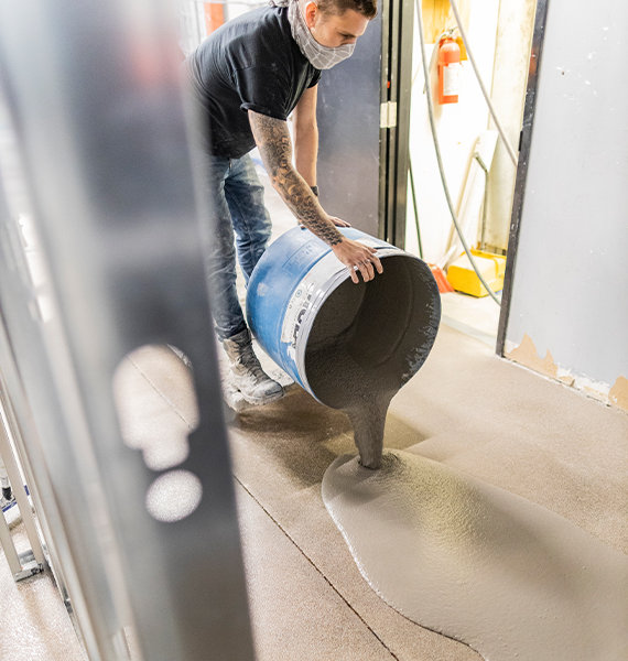 BNE Concrete Floors employee pouring concrete topping for levelling 